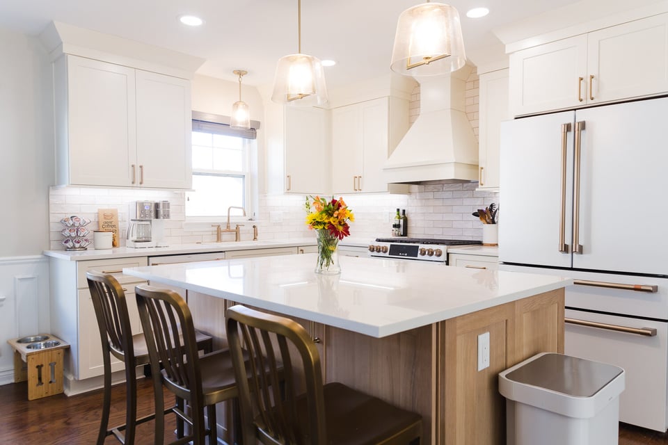 Bright transitional kitchen design in Oakland County, Michigan featuring white cabinets and brass hardware by Cabinet Creations