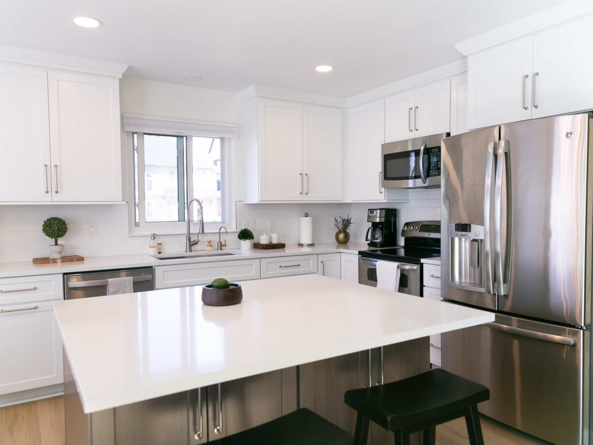 Image of a kitchen remodel with white cabinets, island, and stainless steel appliances in Oakland County, MI by Cabinet Creations Image of a kitchen remodel with white cabinets, island, and stainless steel appliances in Oakland County, MI by Cabinet Creations