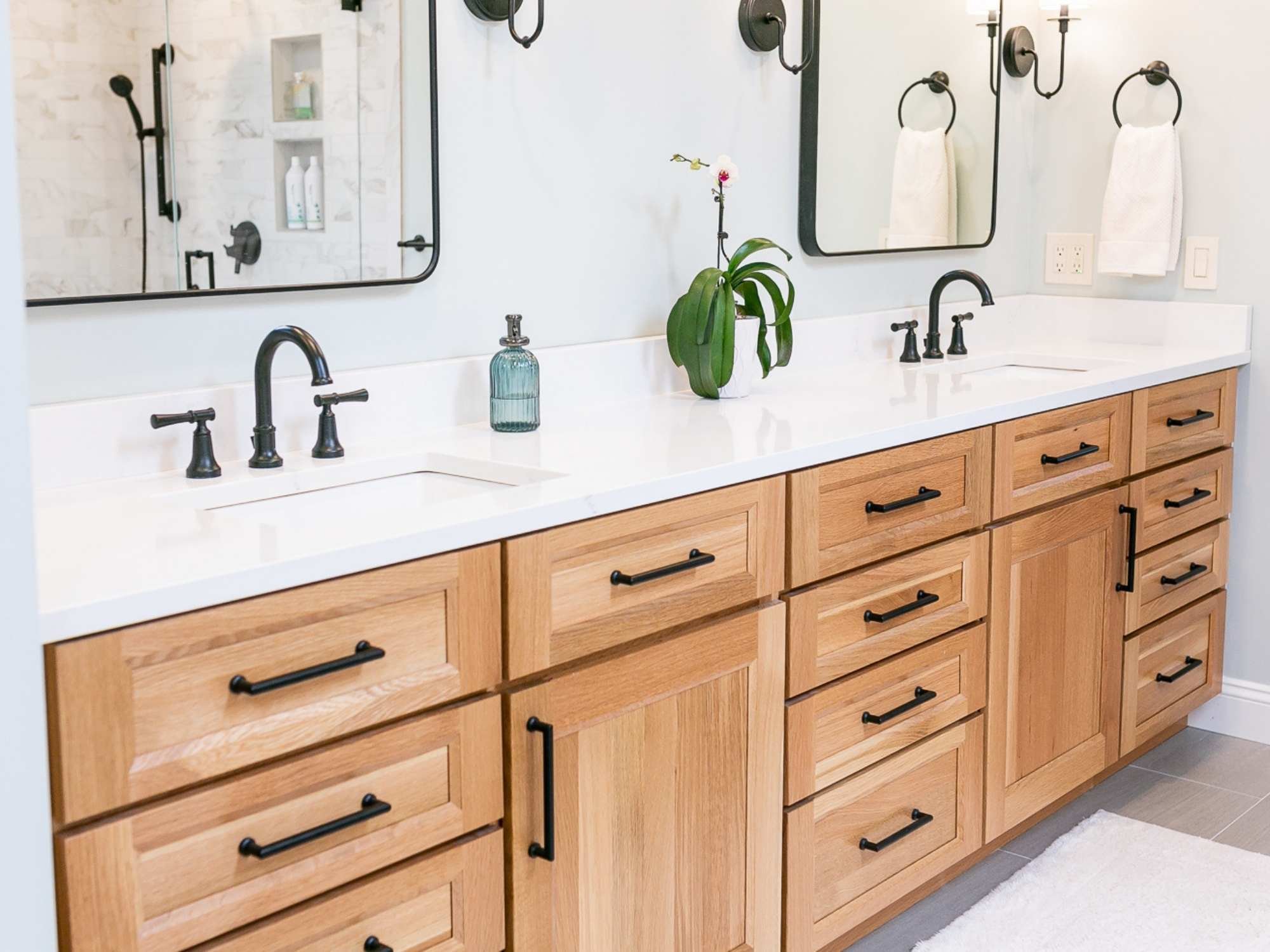 Image of bathroom remodel with double vanity, wood cabinets, and quartz countertop in Oakland County, MI by Cabinet Creations