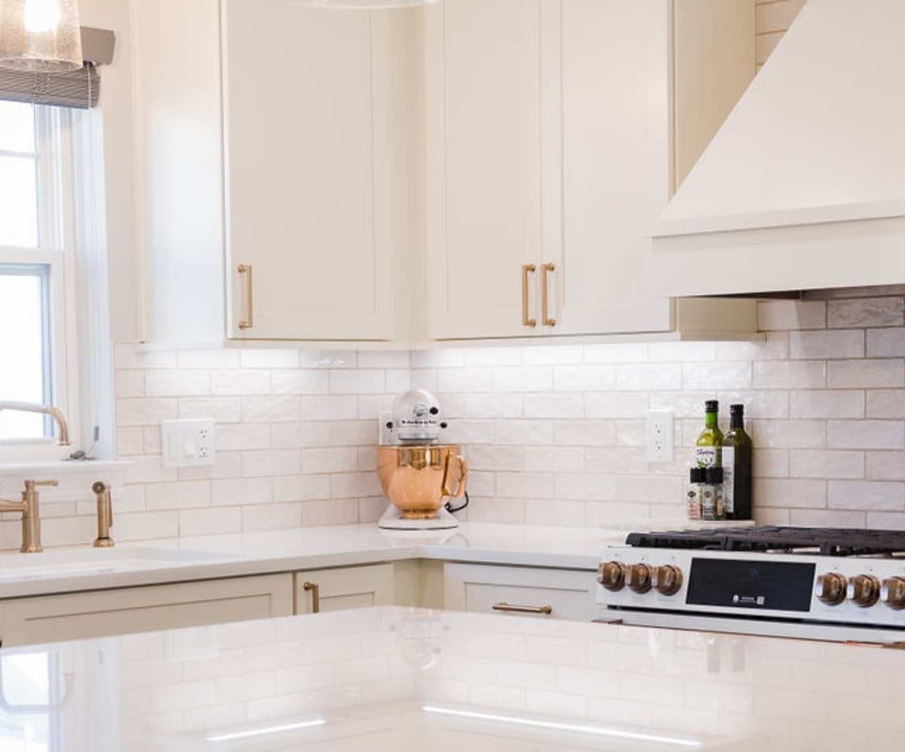 Bright kitchen corner featuring quartz counters, white cabinetry, and a glossy white tile backsplash by Cabinet Creations in Michigan