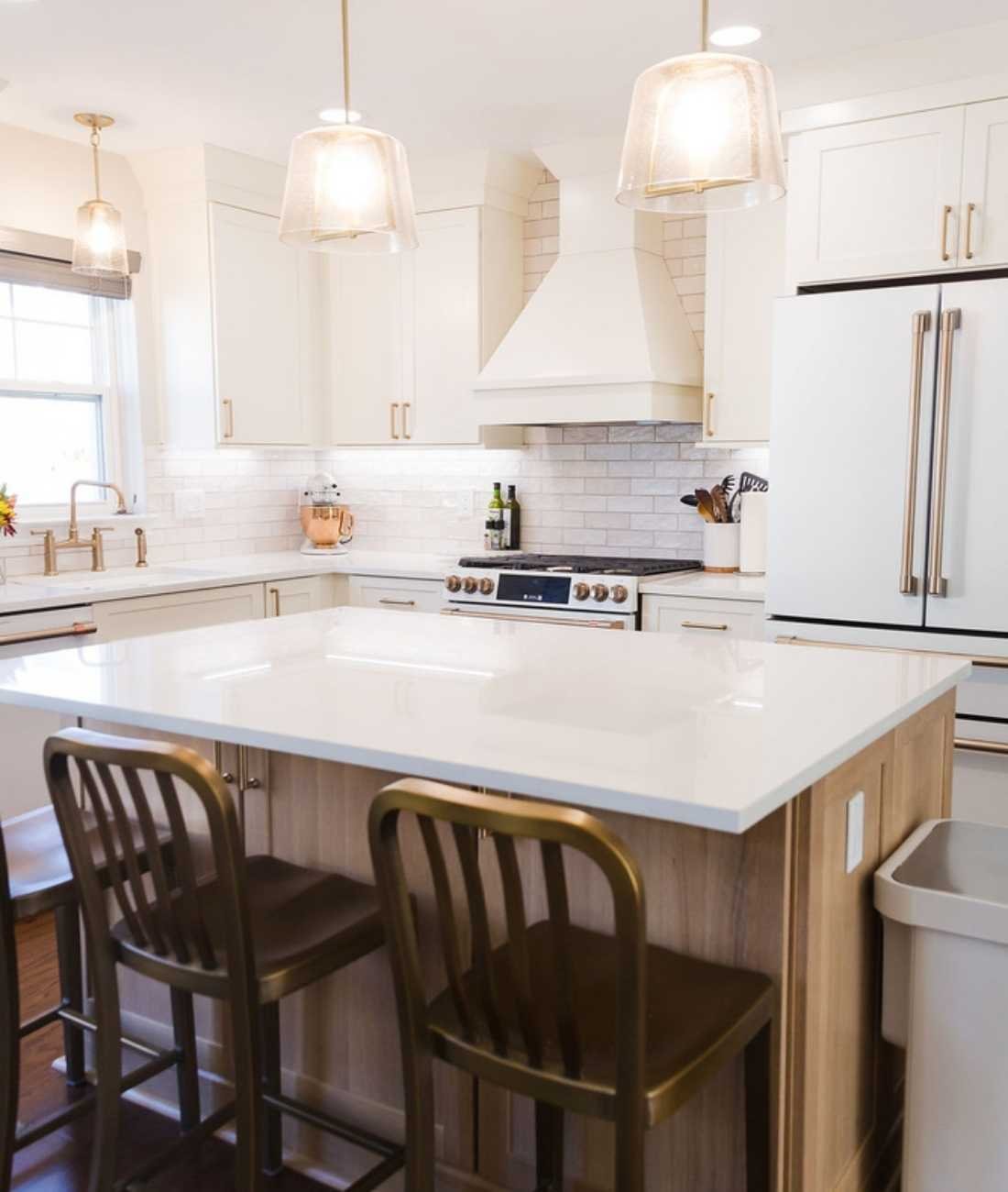 Bright kitchen featuring white cabinetry and large island design in Oakland County, Michigan