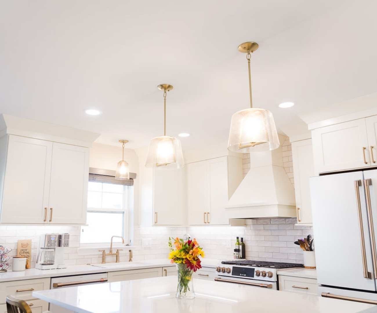 Custom kitchen with quartz island, pendant lighting, and white cabinetry by Cabinet Creations in Ferndale, MI Custom kitchen with quartz island, pendant lighting, and white cabinetry by Cabinet Creations in Ferndale, MI