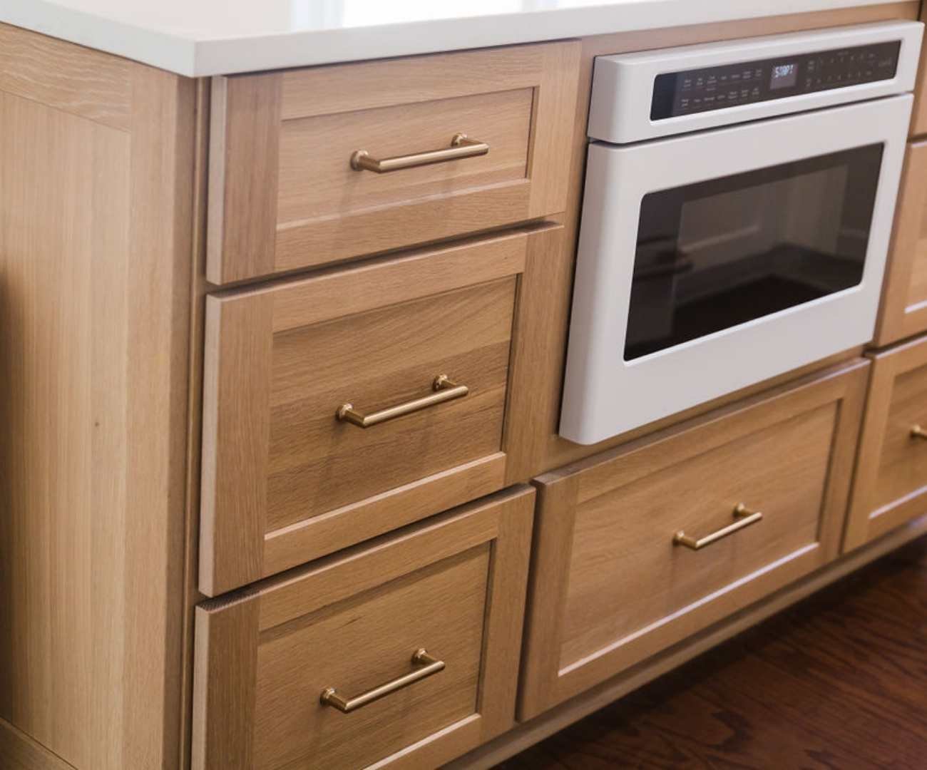 Light wood island cabinetry with built-in oven and brass handles by Cabinet Creations in Oakland County, MI Light wood island cabinetry with built-in oven and brass handles by Cabinet Creations in Oakland County, MI