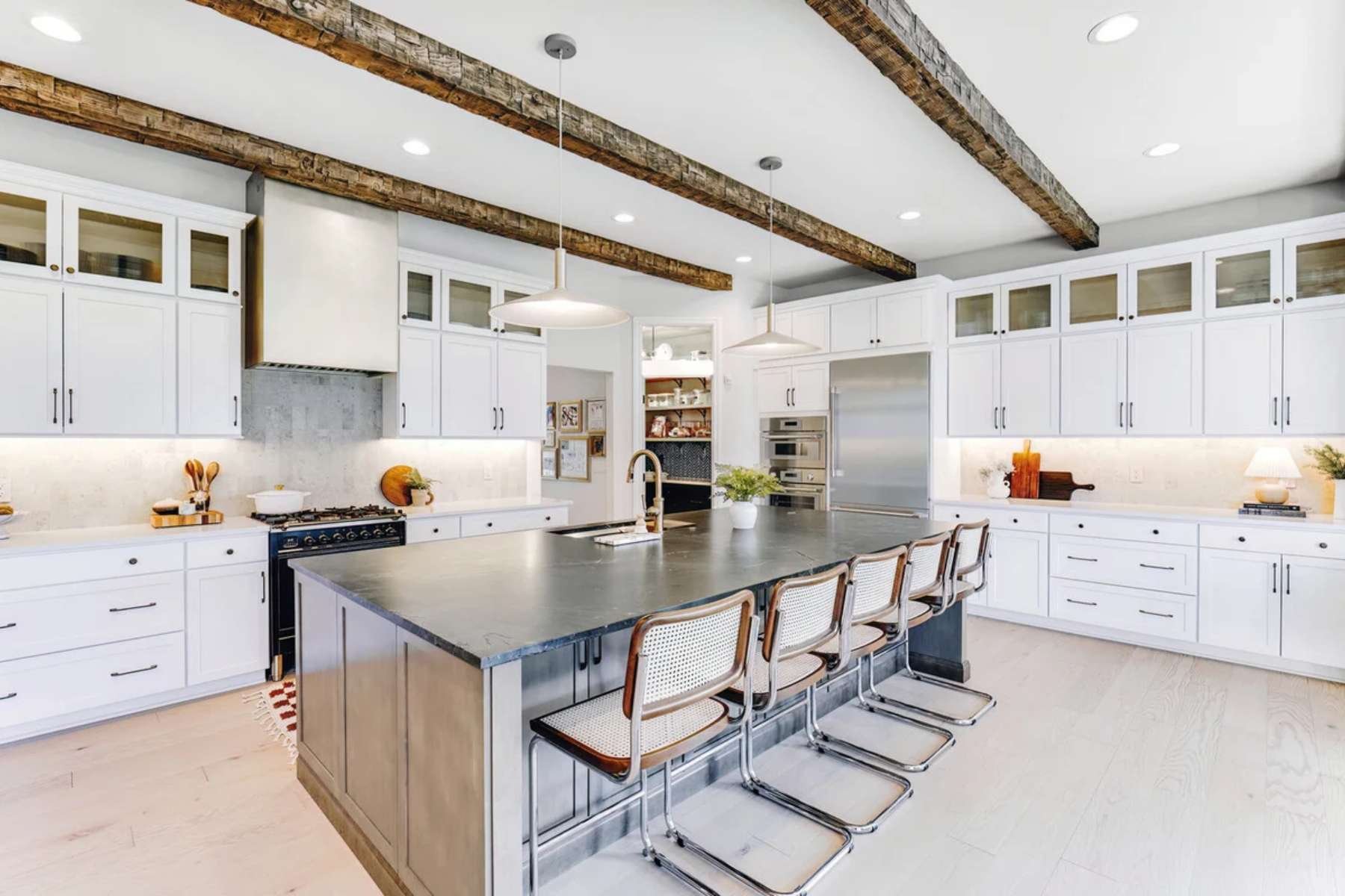 Custom kitchen remodel in Rochester, MI by Cabinet Creations with white cabinetry, island seating, and beams