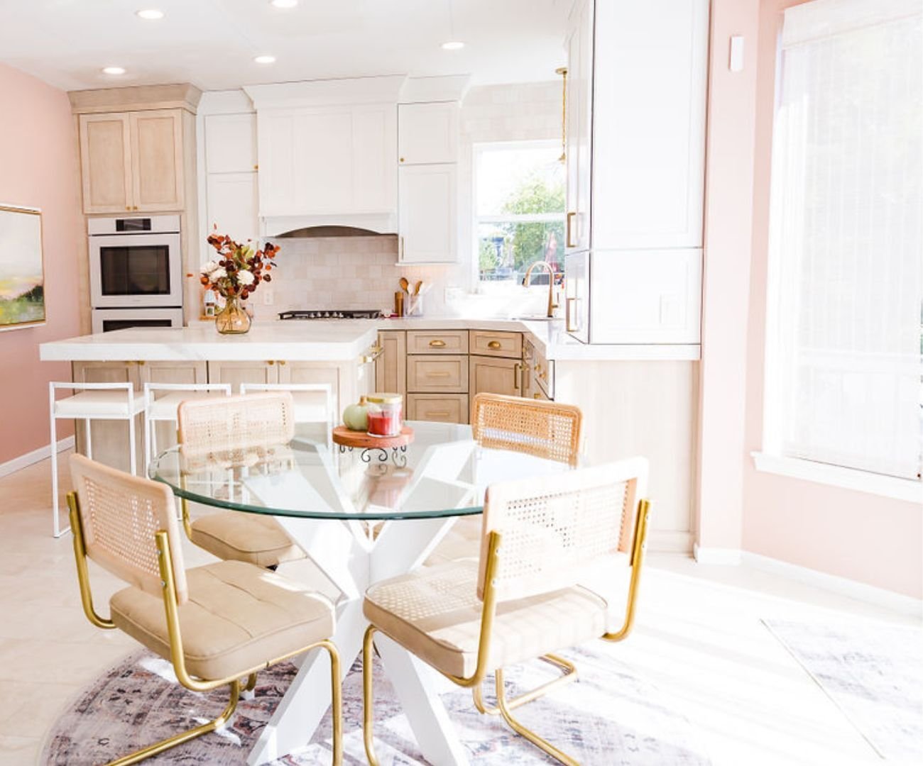 An open dining area and kitchen remodel filled with natural light featuring a soft pink accent wall by Cabinet Creations in Oakland County, MI