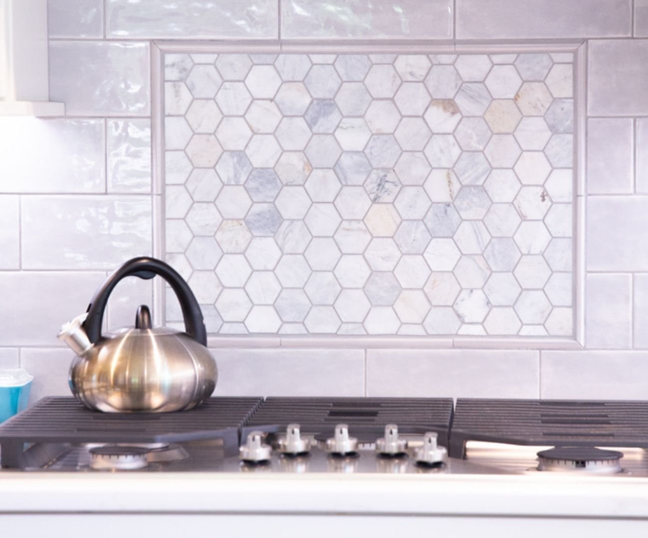 Custom kitchen remodel with stainless kettle and hex tile backsplash by Cabinet Creations in White Lake, Michigan