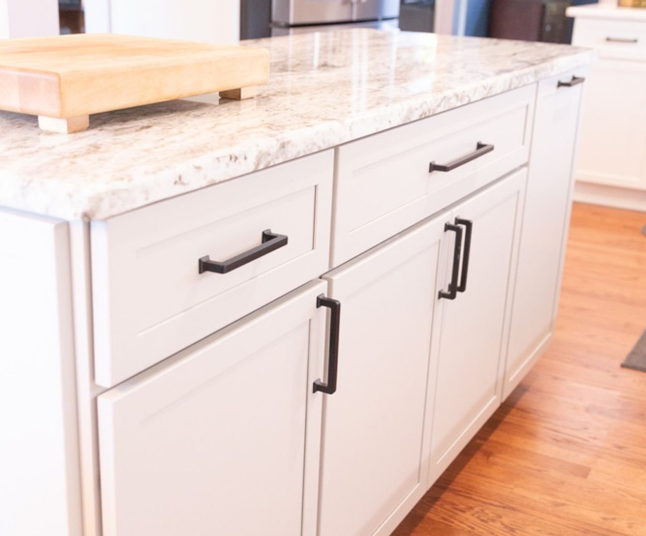 Elegant kitchen space featuring granite island and white shaker cabinets by Cabinet Creations in Oakland County, MI