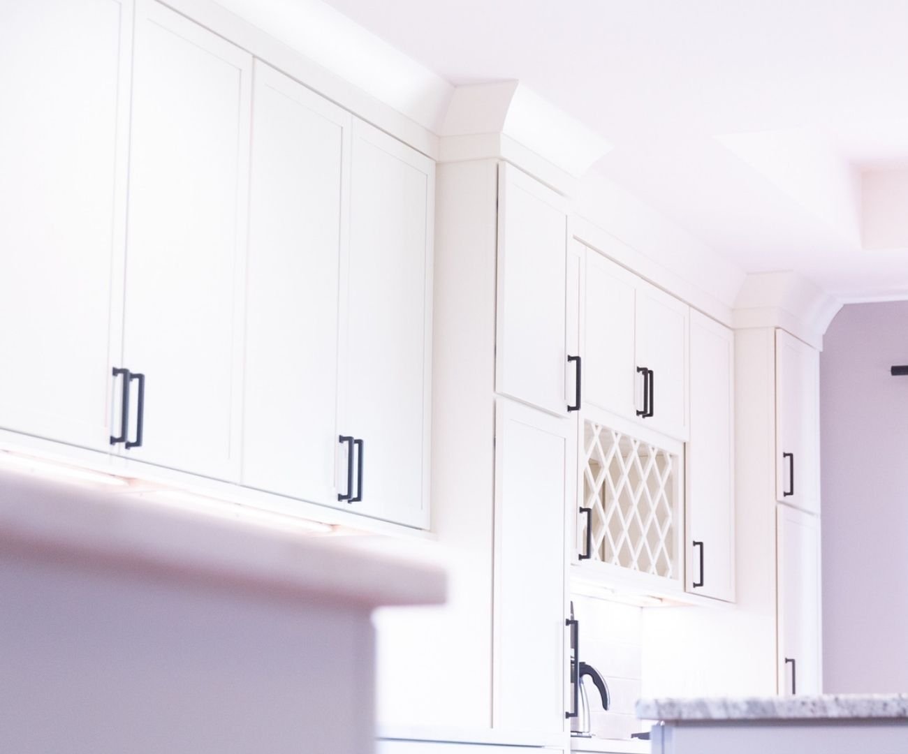 Elegant upper cabinetry and wine storage area by Cabinet Creations in White Lake, Michigan