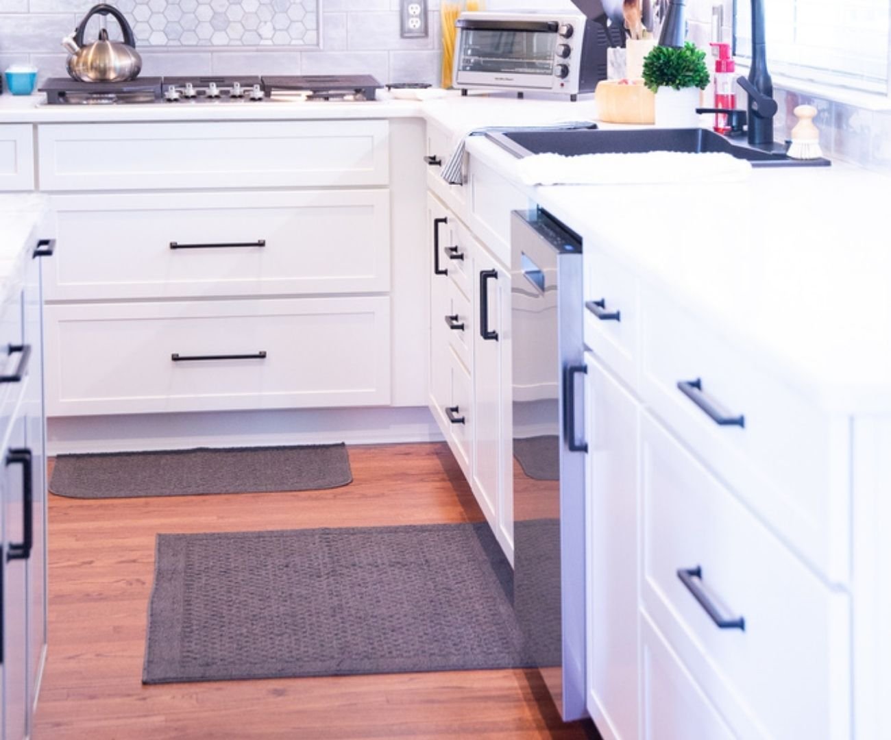 Open custom kitchen remodel with bright cabinetry and black fixtures by Cabinet Creations in White Lake, Michigan