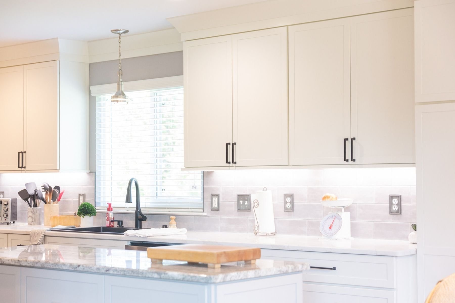 Custom kitchen with white shaker cabinets and granite island by Cabinet Creations in White Lake, Michigan