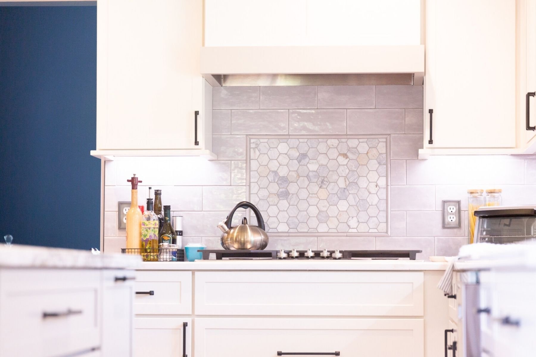 Elegant custom kitchen backsplash with hexagon tile design by Cabinet Creations in White Lake, Michigan