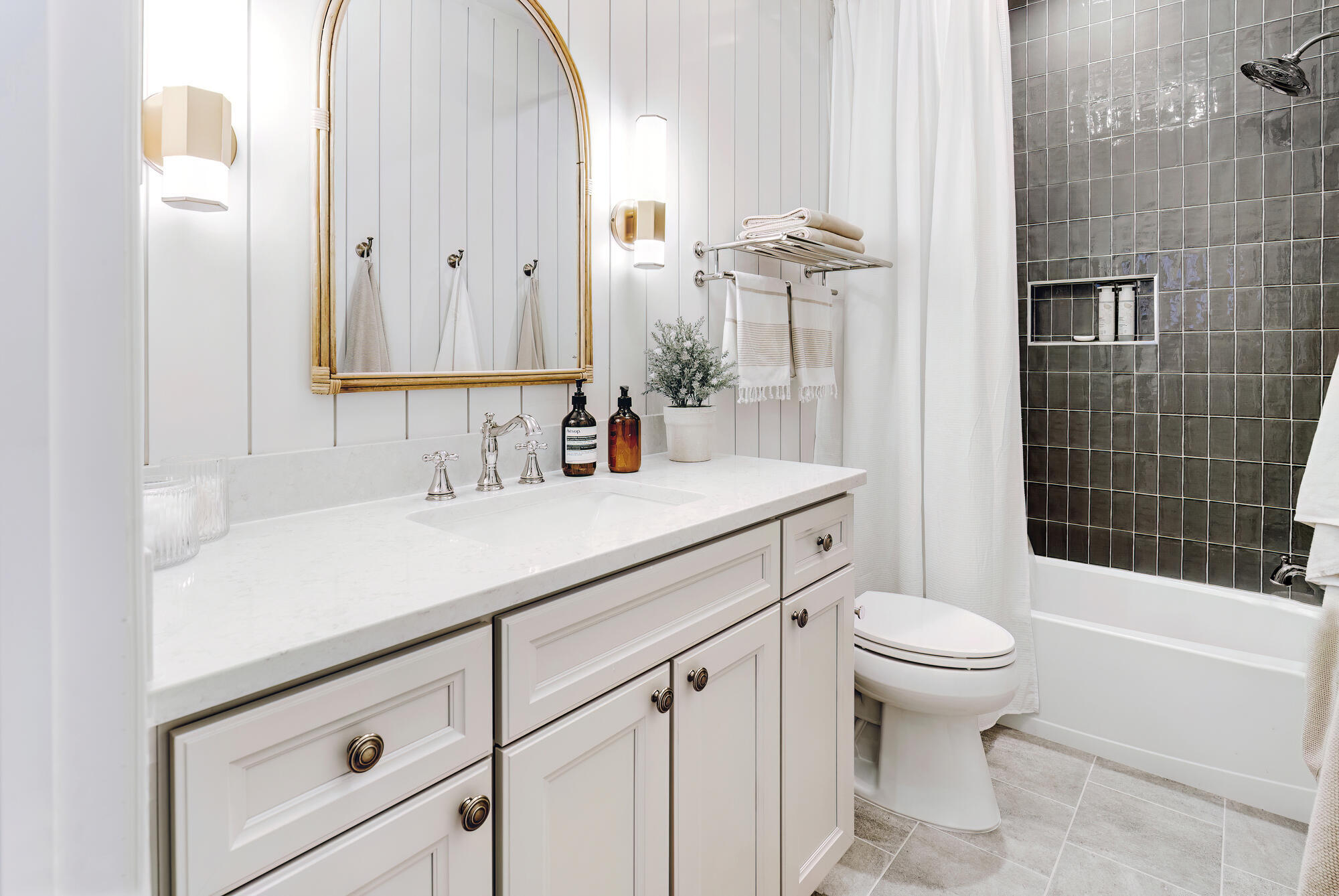 Classic white vanity and black tiled shower in Clarkston bathroom remodel by Cabinet Creations