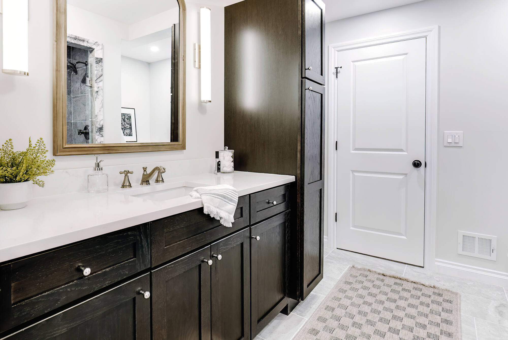 Elegant bathroom remodel in Clarkston, MI featuring warm-toned finishes and functional storage by Cabinet Creations