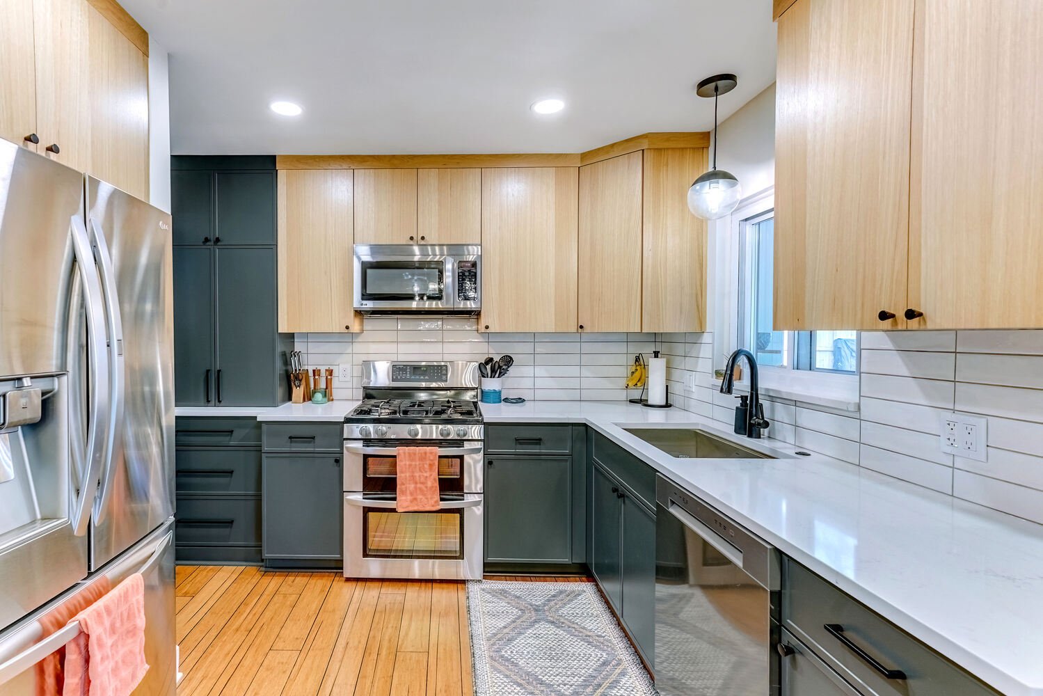 Oakland County custom kitchen featuring horizontal tile backsplash and modern pendant lighting by Cabinet Creations
