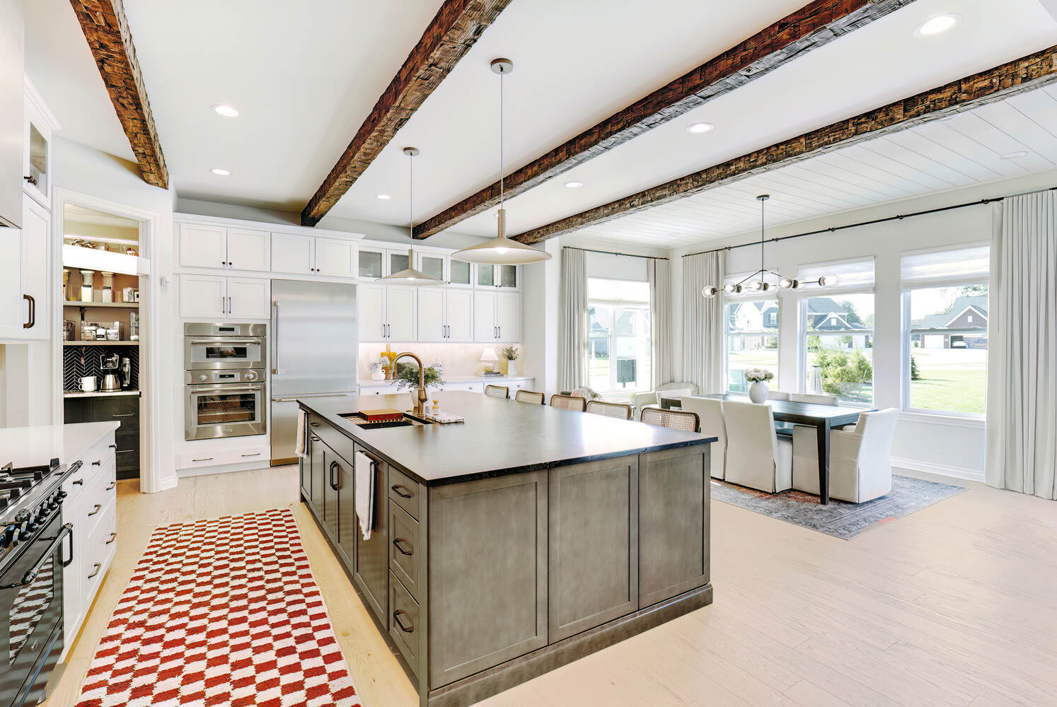 High-end kitchen design with deep-toned island and white shaker cabinets in White Lake, MI