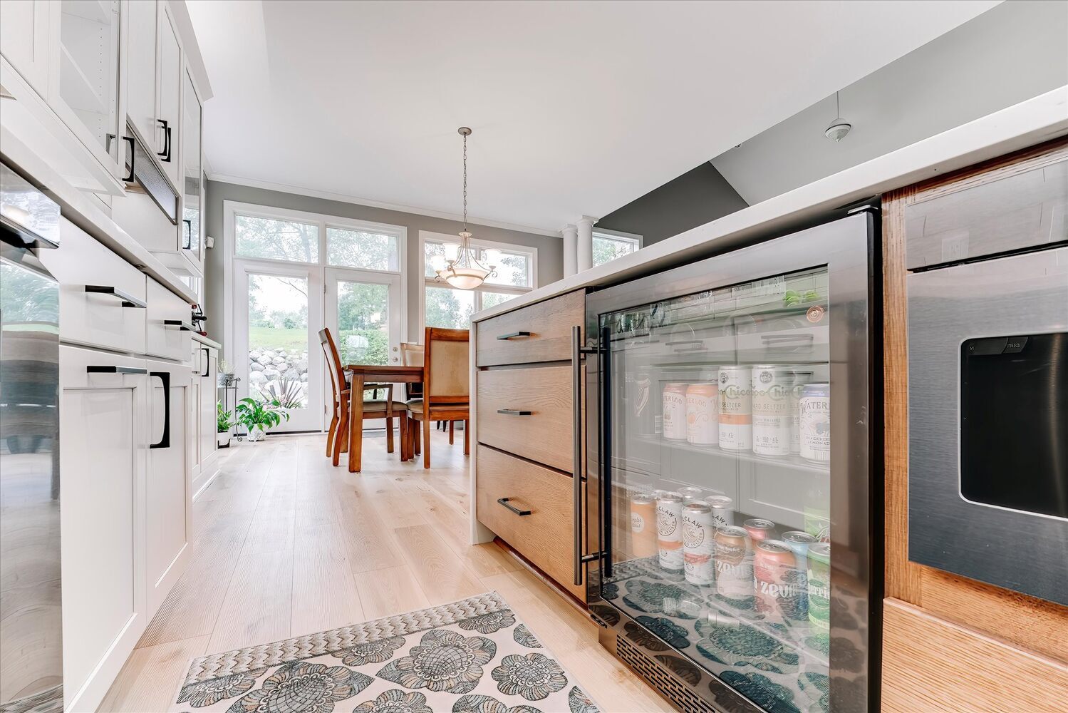 Close-up of glass beverage fridge stocked with drinks in a custom kitchen by Cabinet Creations