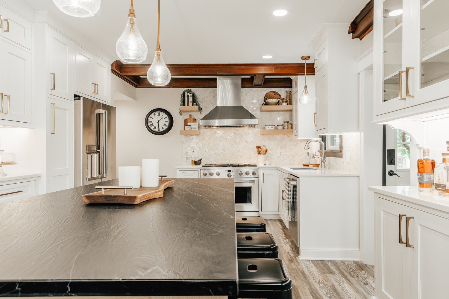 Lake Orion custom home kitchen with wood island and tufted dining chairs by Cabinet Creations