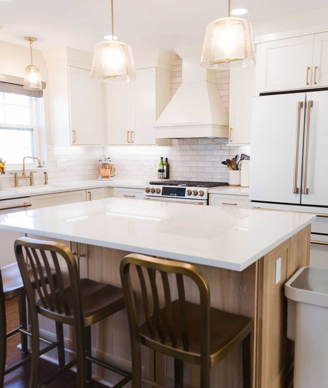 Bright kitchen featuring white cabinetry and large island design in Oakland County, Michigan