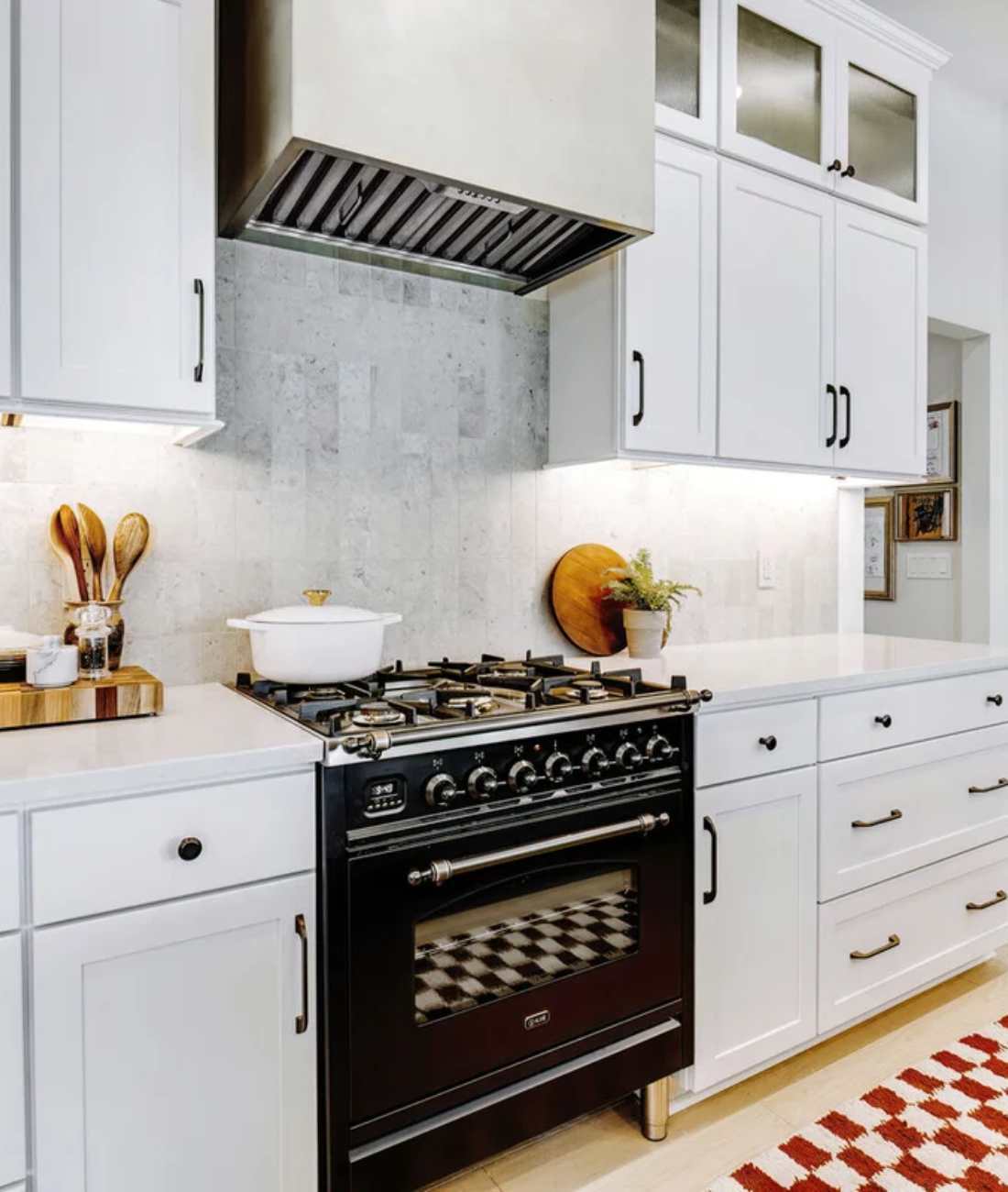 Custom kitchen remodel by Cabinet Creations in Rochester, MI with white cabinetry, range hood, and cooktop