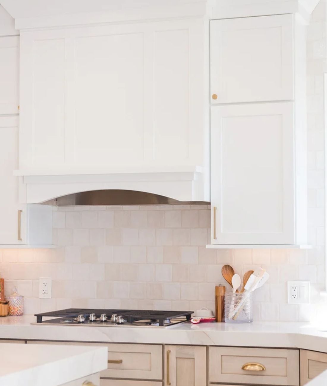 Bright custom kitchen design with gas cooktop and white tile backsplash in a White Lake Township home