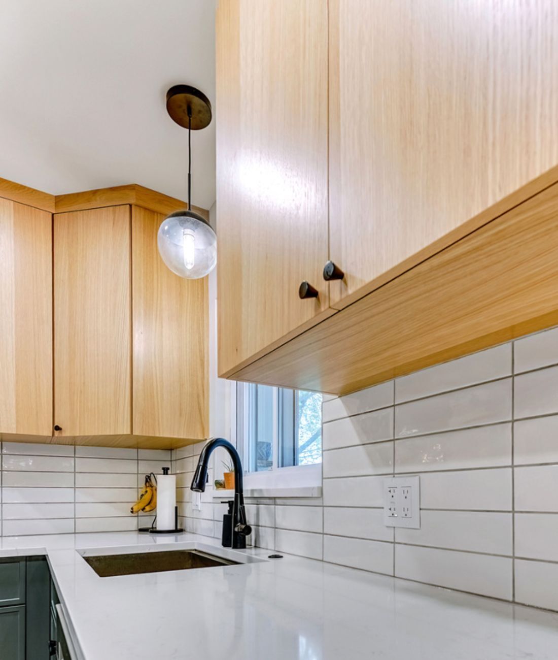 Close-up of kitchen countertop with pendant lighting and modern cabinetry in Clarkston, MI by Cabinet Creations