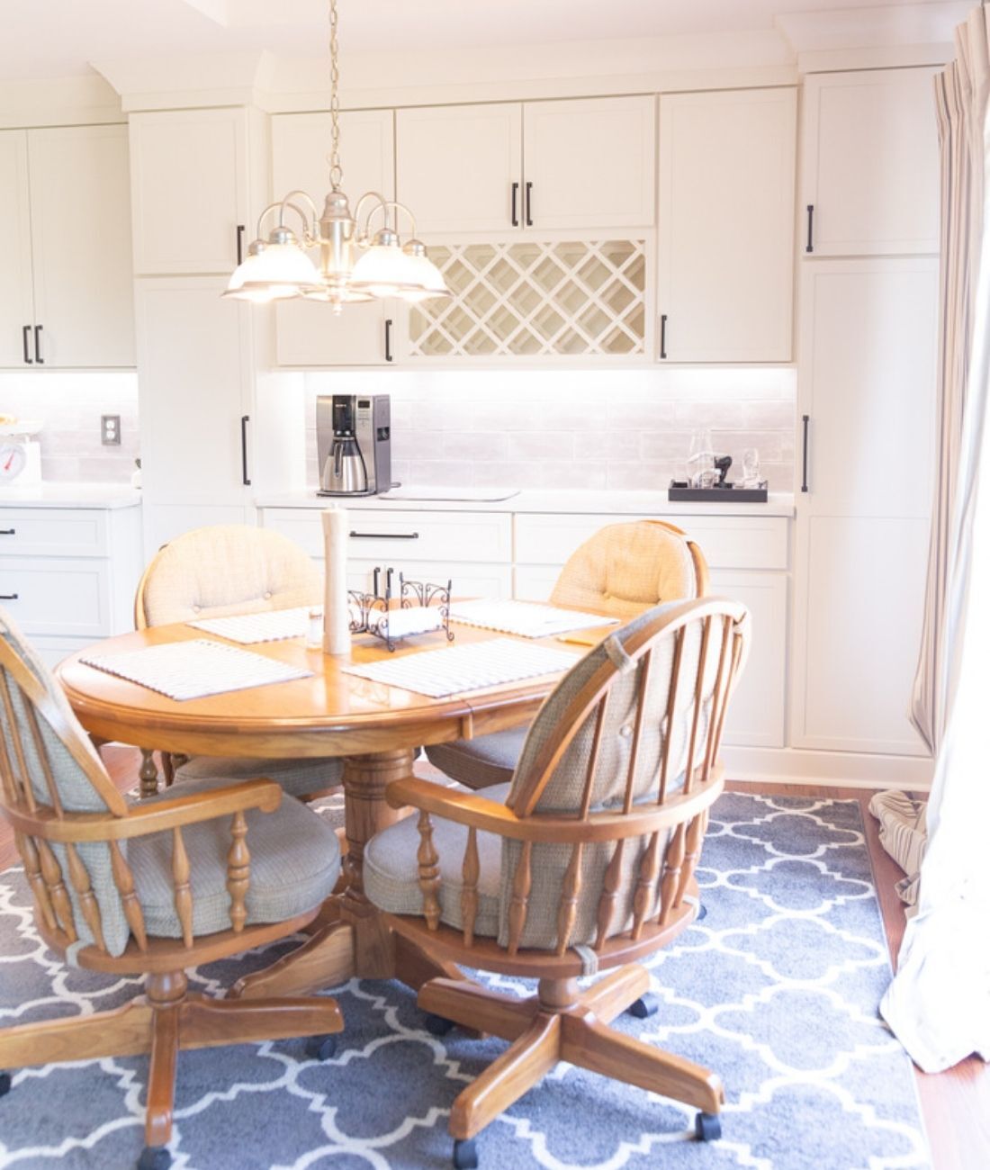 Custom kitchen and dining space with chandelier and white cabinetry by Cabinet Creations in White Lake, MI