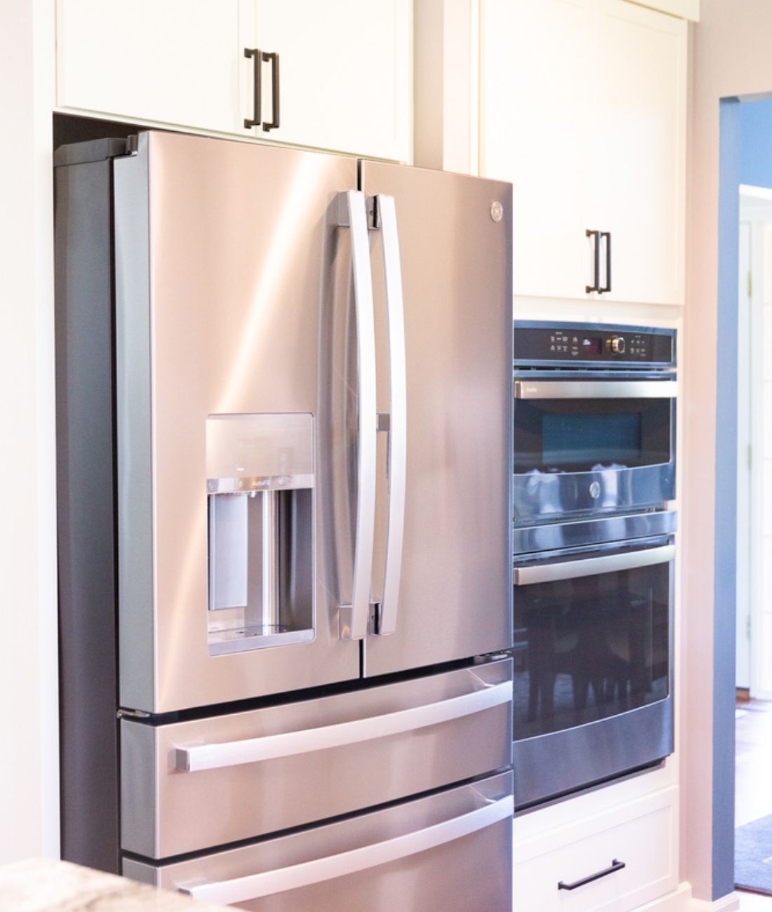 Modern kitchen design featuring white cabinetry and stainless appliances by Cabinet Creations in Oakland County, MI