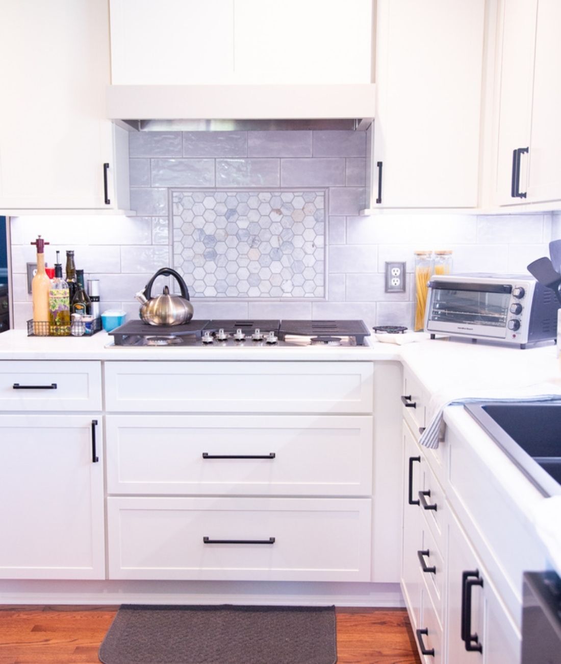 Transitional kitchen design featuring gray backsplash and under-cabinet lighting by Cabinet Creations in Oakland County, MI